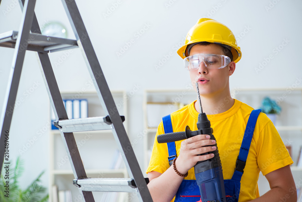 Young repairman with power drill Young repairman with power drill