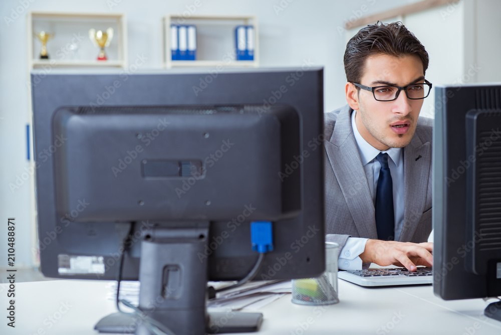 Businessman sitting in front of many screens Businessman sitting in front of many screens