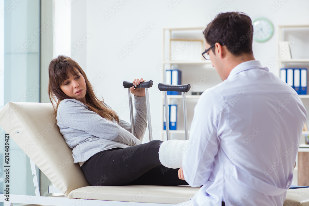 Doctor examining patient with broken leg Doctor examining patient with broken leg