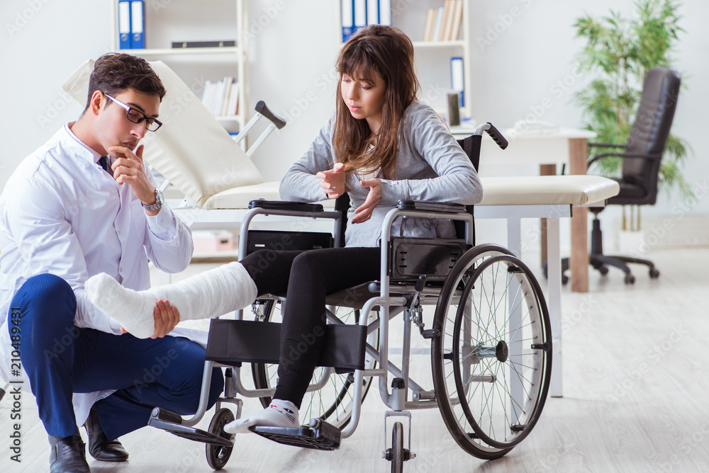 Male doctor examining female patient on wheelchair Male doctor examining female patient on wheelchair