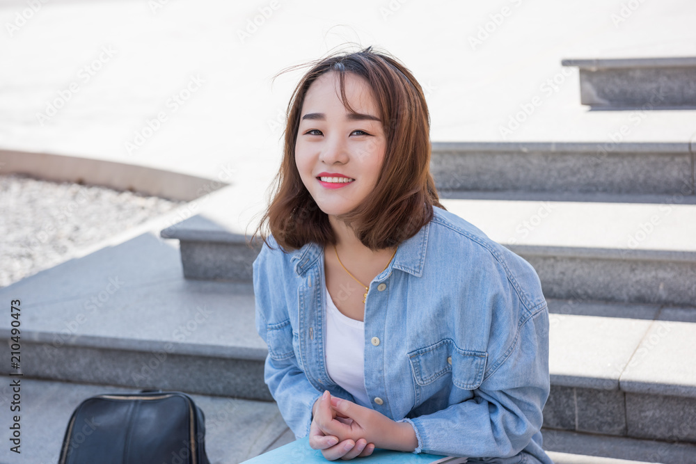 Attractive female college student sitting on stairs