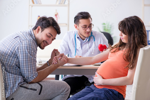 Pregnant woman with her husband visiting the doctor in clinic