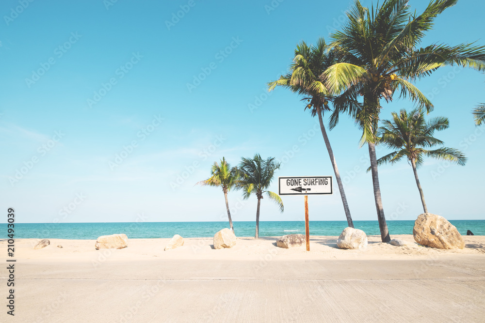 Landscape of coconut palm tree on tropical beach in summer. beach sign for surfing area. Vintage effect color filter.