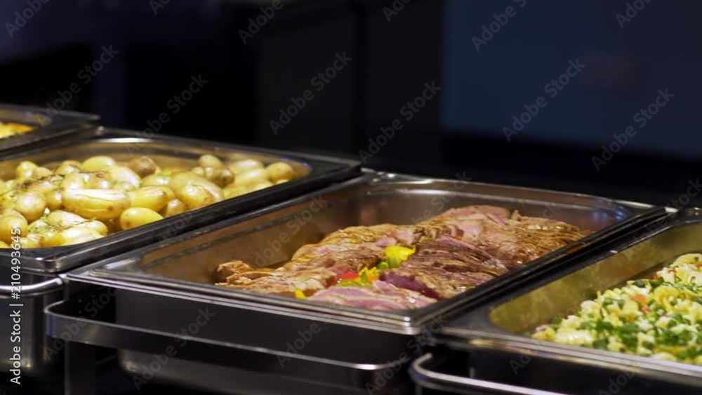 Restaurant guests select food from a buffet. Restaurant guests select food from a buffet.
