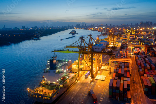 Aerial view of business port with shore crane loading container in container ship in import/export and business logistics with crane and shipping port cargo.International port concept.