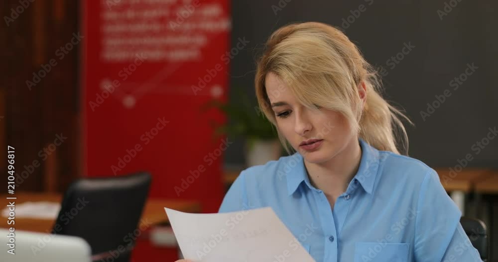 Young girl working with documents in modern office. Skilled professional female administrative manager checking documentation. Young girl working with documents in modern office. Skilled professional female administrative manager checking documentation.