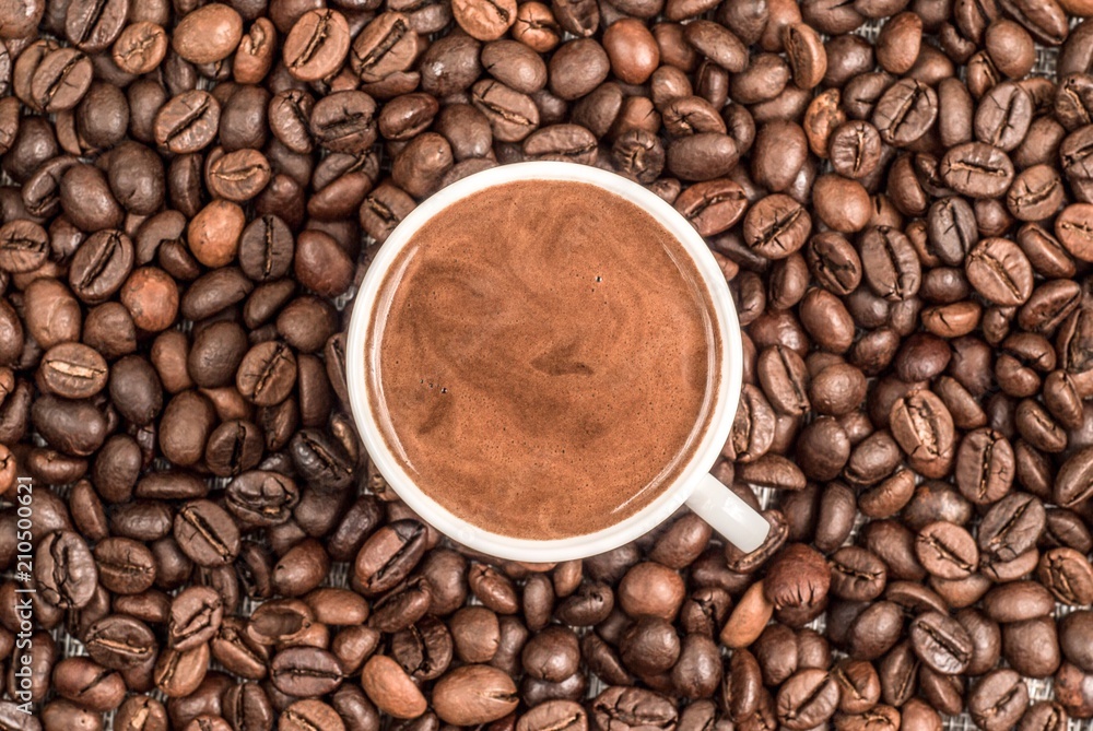 Fototapeta premium Fresh coffee surrounded by coffee beans