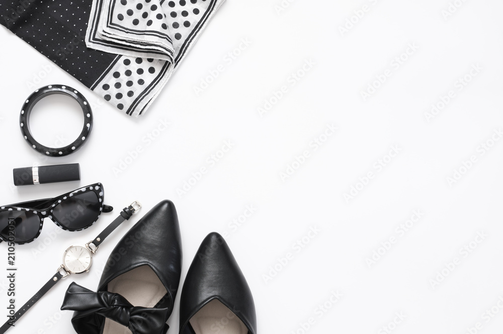 Set of black and white woman clothes and accessories on white background. Top view point, flat lay.