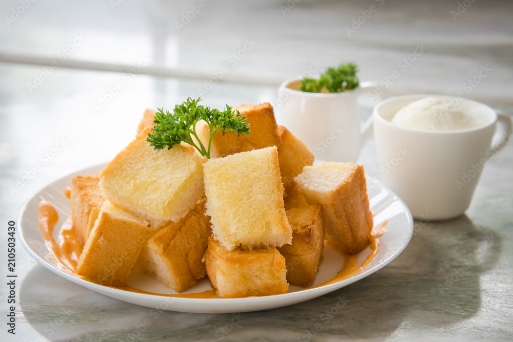 Toast is turned into small pieces and Thai tea with ice cream. and dripping sauce on top Toast is turned into small pieces and Thai tea with ice cream. and dripping sauce on top