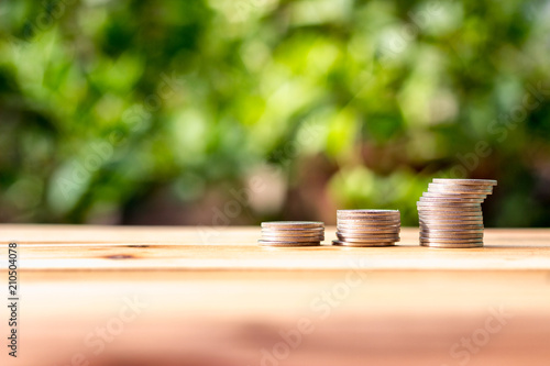 Many coins are placed on wooden boards with background burry