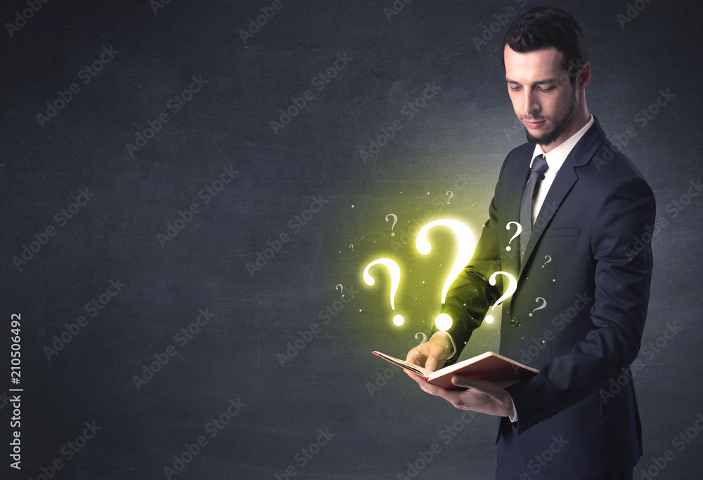 Businessman holding a book with question mark symbol. Businessman holding a book with question mark symbol.