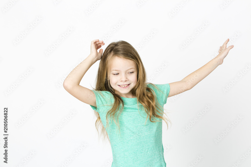 beautiful young girl is happy and dancing and posing in the studio in front of white background beautiful young girl is happy and dancing and posing in the studio in front of white background