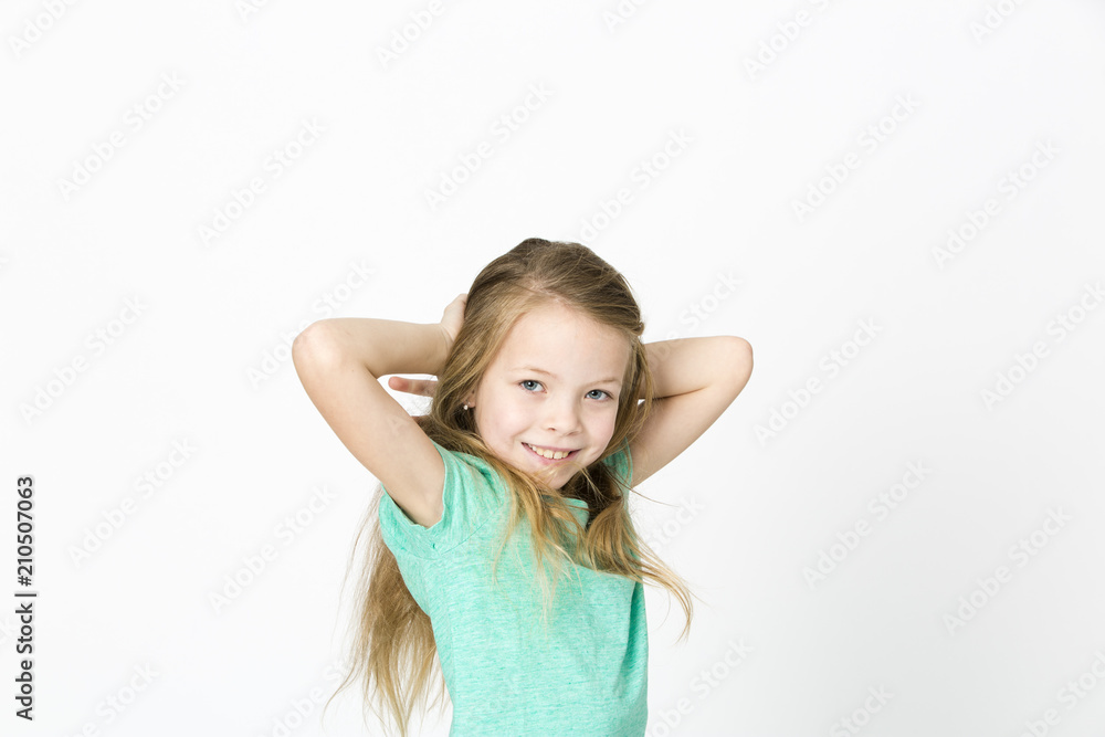 beautiful young girl is happy and dancing and posing in the studio in front of white background beautiful young girl is happy and dancing and posing in the studio in front of white background