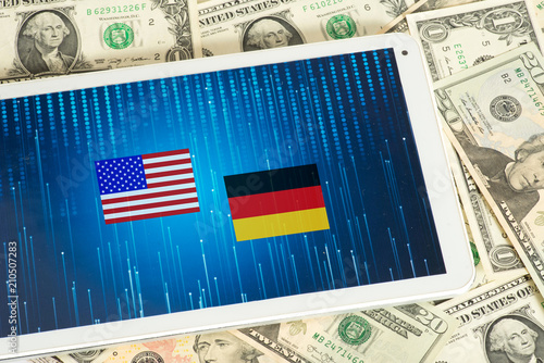 Dollar Geldscheine, Tablet PC und Flaggen von USA und Deutschland photo