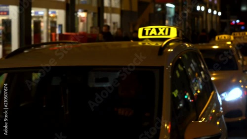 : Hand held panning night time video of taxis and people in Rosenthaler Strasse, Berlin, Germany