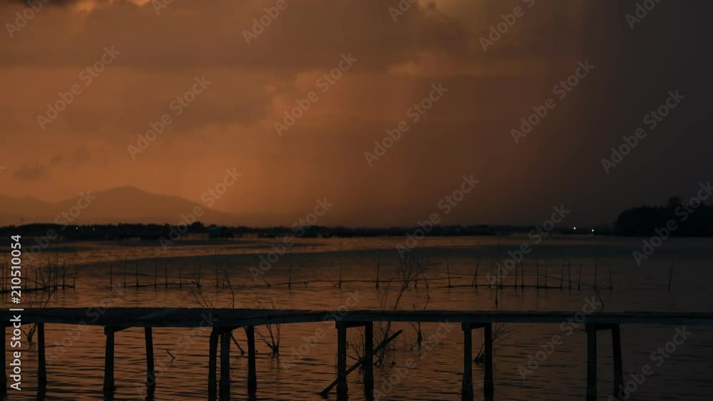 Approaching storm cloud with rain over the sea during sunrise Approaching storm cloud with rain over the sea during sunrise