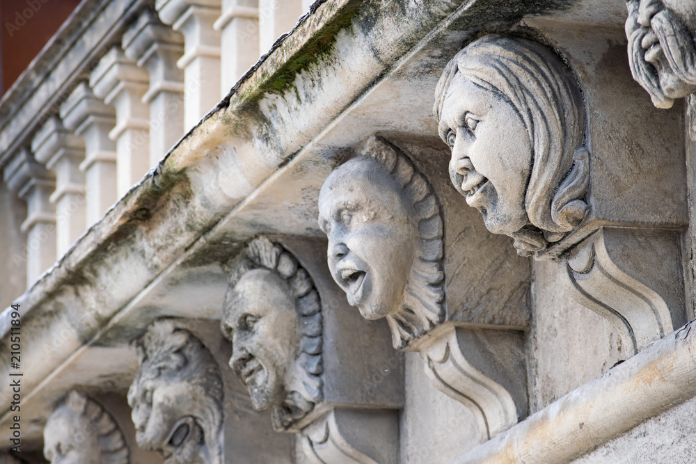 Closeup view of mascarons with funny faces under the balcony of a baroque palace in the province of Syracuse, Sicily Closeup view of mascarons with funny faces under the balcony of a baroque palace in the province of Syracuse, Sicily