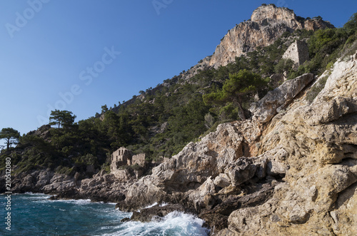 Ruins of the ancient Lycian city on the Mediterranean coast; Ancient Greek city on the coast in the background of forest, rocks and mountains; Lycian way in Turkey in the area between Kabak and Potara
