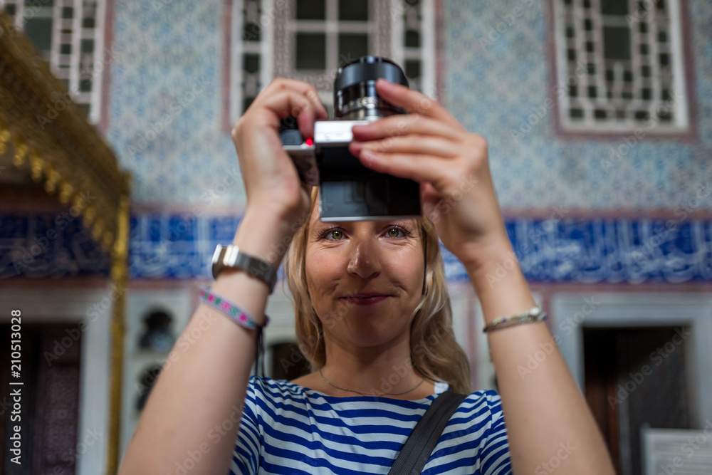 Caucasian woman making a photo in the Topkapi Palace in Istanbul, Turkey
