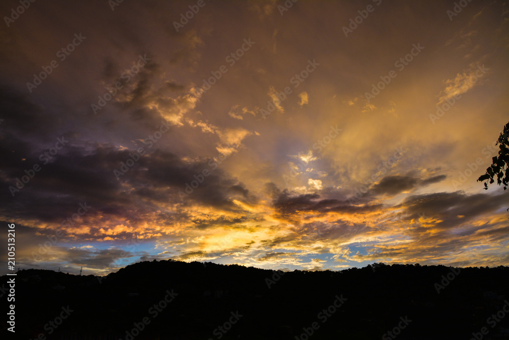 Dark dramatic clouds with golden horizon on the sky at dusk