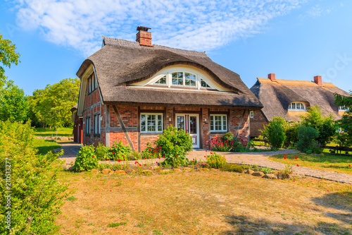 Obraz na płótnie Traditional house with straw roof and sunny blue sky in Middelhagen village, Ruegen island, Baltic Sea, Germany w salonie