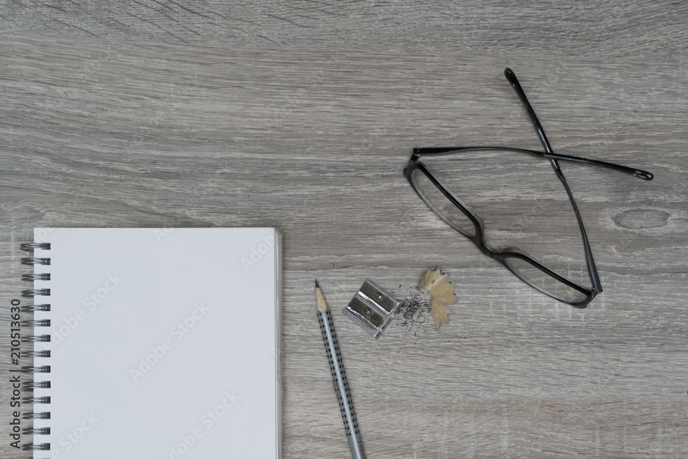 the desk with glasses, a pencil and a clipboard the desk with glasses, a pencil and a clipboard