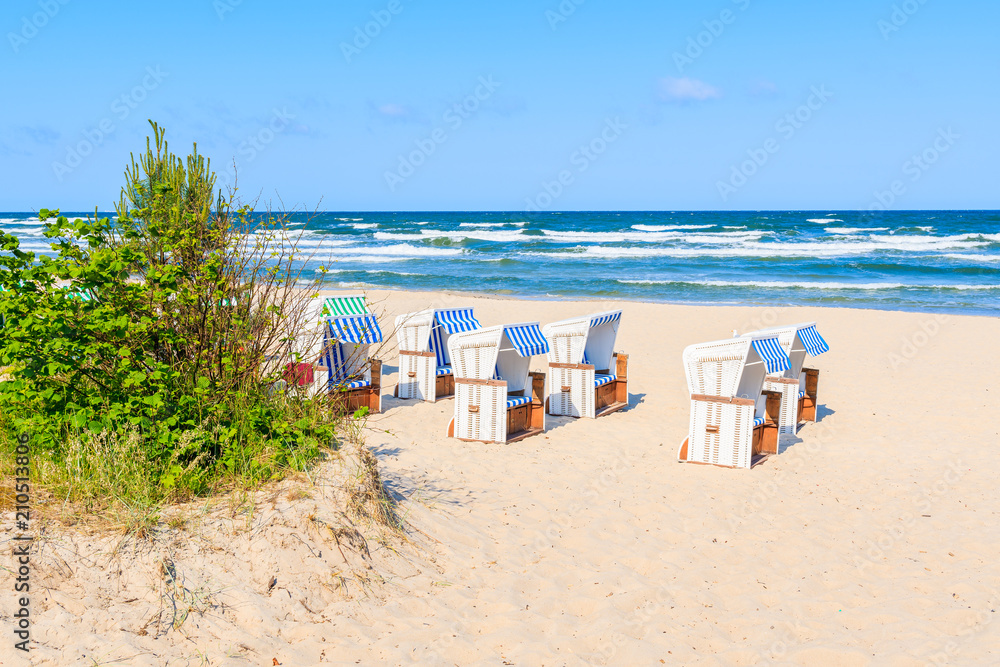 Traditional wicker chairs on sandy beach in Baabe town, Ruegen island, Baltic Sea, Germany