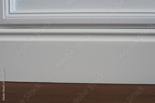 Matte wall, white baseboard and tiles