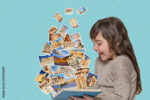 The laughing attractive long hair girl is looking at an open book from which fly photos of Egypt  sights take off. All the photos are from my portfolio. photo