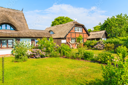 Traditional houses with thatched roofs and sunny blue sky in Middelhagen village, Ruegen island, Baltic Sea, Germany