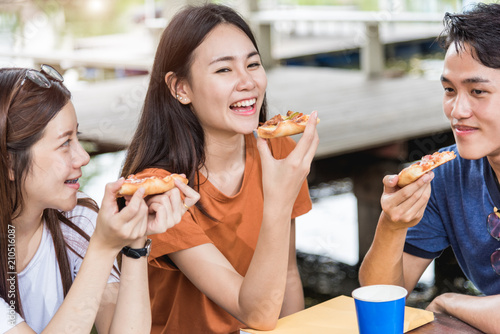 Students group woman and man eating pizza together