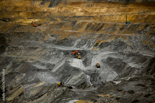 Open coal mine. Heavy machinery at work. Autumn landscape. Heavy mining industry.