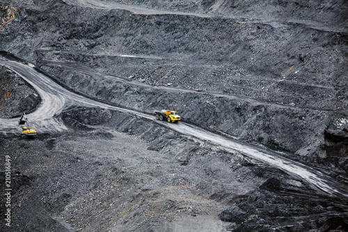 Heavy articulated dump truck on the road in an open coal mine. Heavy mining industry.