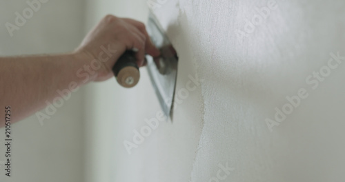 closeup worker applying decorative concrete plaster on the wall photo