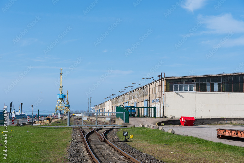 Obraz premium Railroad tracks towards the pier at port of Rostock in Germany