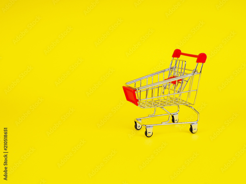 supermarket trolley on yellow background, empty, Concept of shopping. Copy space for advertisement. supermarket trolley on yellow background, empty, Concept of shopping. Copy space for advertisement.