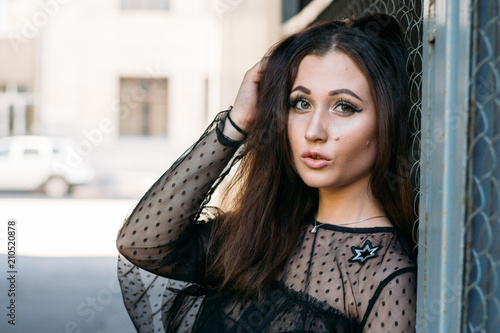 Emotional portrait of Fashion stylish portrait of pretty young woman. city portrait. sad girl. brunette in a black dress. expectation. dreams