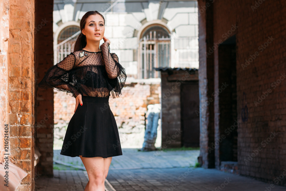 the girl is posing. Emotional portrait of Fashion stylish portrait of pretty young woman. city portrait. sad girl. brunette in a black dress. expectation. dreams