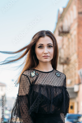 Emotional portrait of Fashion stylish portrait of pretty young woman. city portrait. sad girl. brunette in a black dress. expectation. dreams. girl - night in the middle of the day