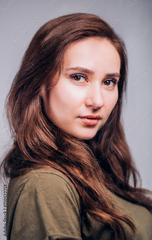 Fototapeta premium Close up portrait of beautiful cute brunette woman on grey background. Positive emotions, facial expression