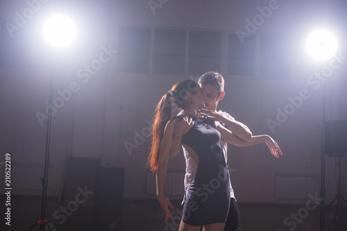 Young couple dancing social danse kizomba or bachata or semba or taraxia in dancing class background