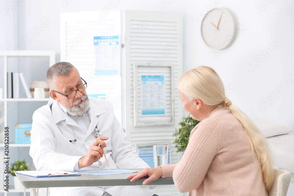 Coughing mature woman visiting doctor at clinic Coughing mature woman visiting doctor at clinic