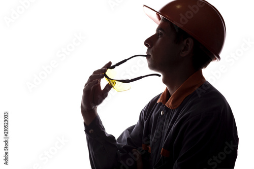 silhouette of a young constructer thinking of a career, a man in a helmet on a white isolated background photo