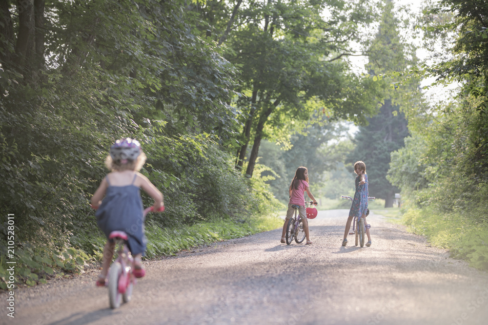 Big Sister Encouraging Little Sister on Bicycles