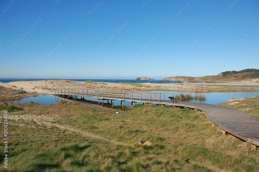 Beach of Doniños in north west of Spain. A wooden bridge cross the river created by the winter's rains.