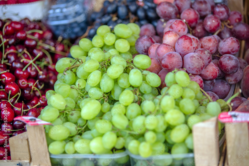 Red and green grapes are on the counter in the store Red and green grapes are on the counter in the store