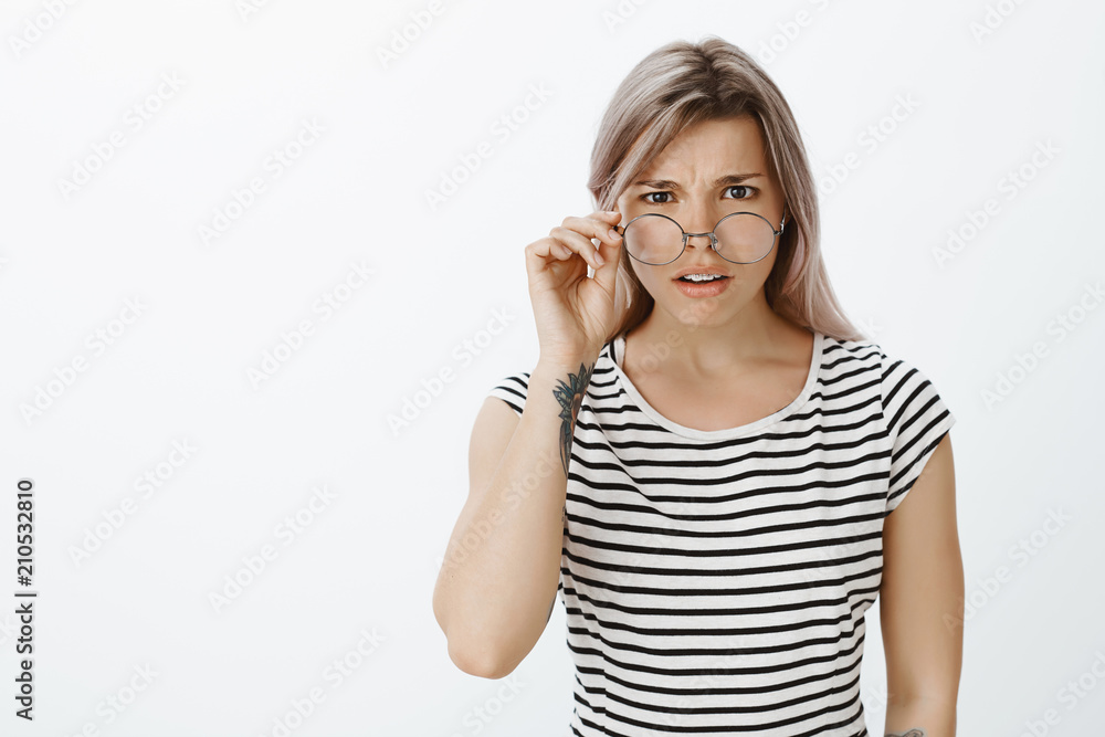 What are you talking about. Portrait of unsure confused attractive blonde, taking off glasses and frowning, being shocked and having no idea what happening, looking with doubt at camera What are you talking about. Portrait of unsure confused attractive blonde, taking off glasses and frowning, being shocked and having no idea what happening, looking with doubt at camera