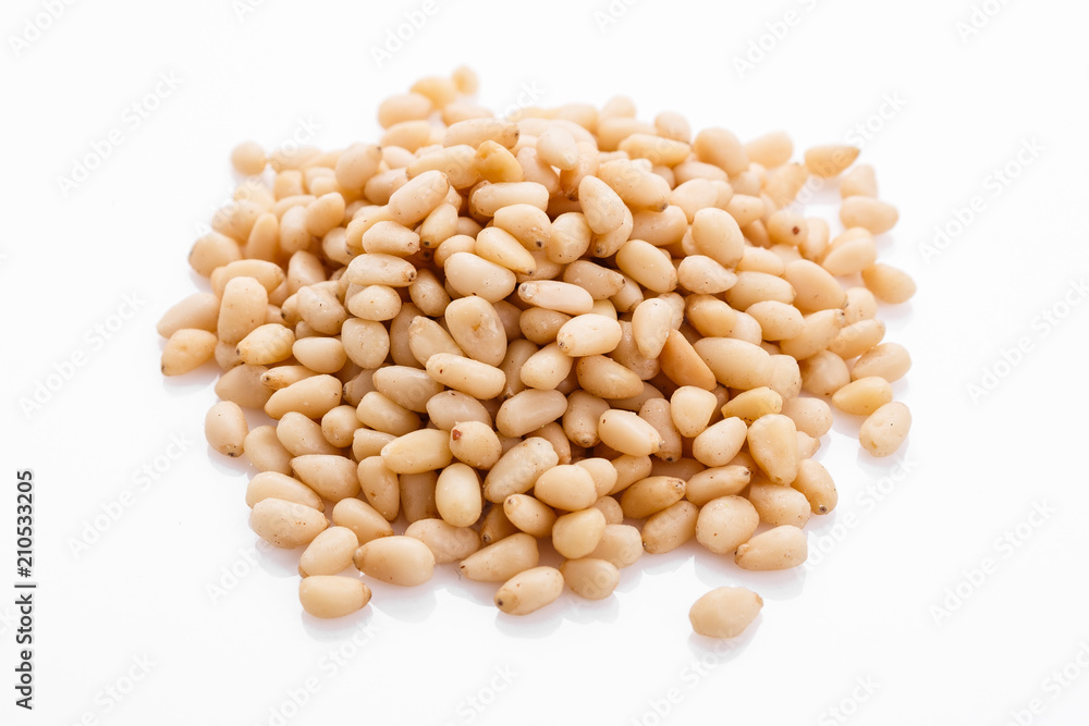 peeled pine nuts on a white acrylic background peeled pine nuts on a white acrylic background