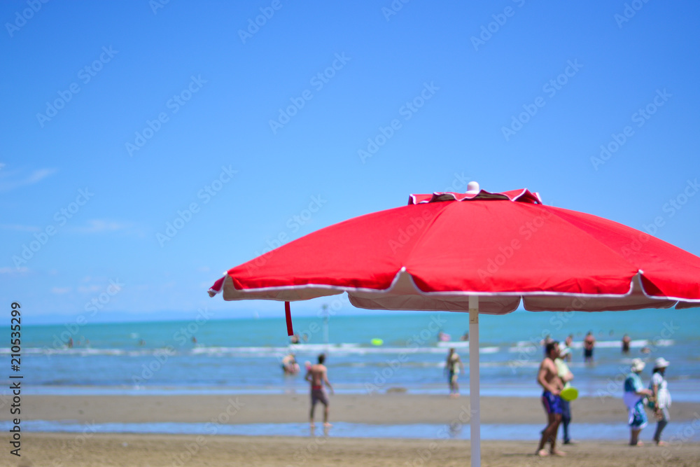 An open red umbrella on the beach