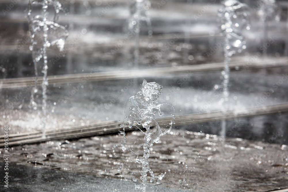 Splashing water from a fountain in the park as a background Splashing water from a fountain in the park as a background